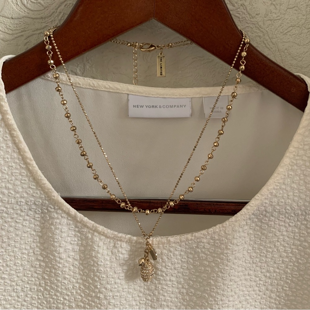 Gold tone layered necklace with oval shiny pendant